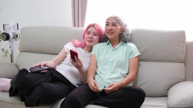 Bir torunun ve büyükannesinin birlikte oturma odasında vakit geçirmesi nesiller arası bir bağ ve kuşaklar arası farklılıkların güzelliğini vurguluyor..