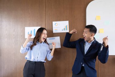 İki profesyonel modern ofiste başarılarını ve takım çalışmalarını kutlayarak keyif ve heyecan ifade ediyorlar..