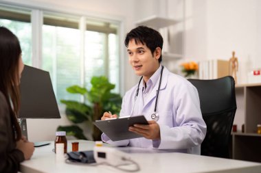 Bir doktor, modern bir sağlık ortamında kişisel bakımı vurgulayan tedavi seçeneklerini bir hastayla tartışır..