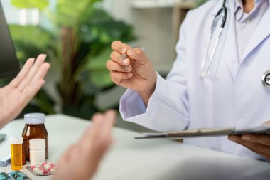 Bir sağlık hizmeti sağlayıcısı, tedaviyi anlamanın önemini vurgulayarak, bir hastayla ilaç seçeneklerini tartışır.