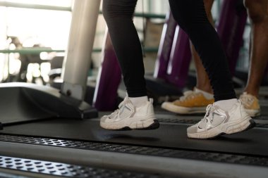 Kişisel antrenör müşterilerine koşu bandında yardım eder, spor salonunda sağlık ve sağlık hizmetlerini teşvik eder..