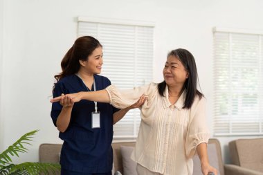 Sıcak kalpli bir bakıcı, yaşlı bir kadına taşınabilirlik egzersizlerinde yardımcı olur. Ev ortamında fiziksel sağlığını ve duygusal sağlığını geliştirir..