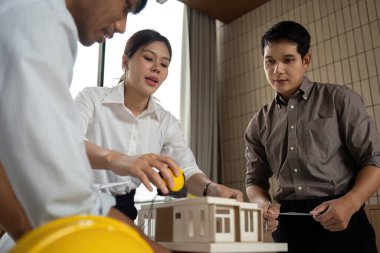 Mimarlar ve mühendislerden oluşan bir ekip, çevre dostu tasarım ve işbirliğini vurgulayan sürdürülebilir bir yapı modeli üzerinde birlikte çalışıyorlar..