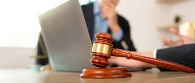 Bir avukat ve müvekkil hukuki danışmanlık yapar, belgeleri analiz eder ve profesyonel bir ortamda dava stratejilerini tartışırlar..