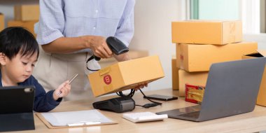 Bir anne paketleri tararken oğlu akıllı telefonuyla oynuyor ve ev işi ortamındaki aile hayatının dinamiklerini anlatıyor..