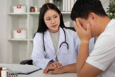 Şefkatli bir doktor, sağlık muayenesi sırasında erkek bir hastanın endişelerini dile getirmesini dinler ve tıbbi ortamlarda duygusal desteğe dikkat çeker..