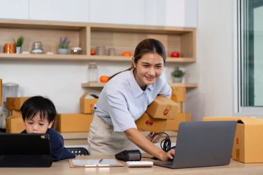 Kendini işine adamış bir anne, küçük çocuğuna bakarken işini yönetiyor. Sahne, modern aile dinamiklerini ve uzak çalışmaları yansıtıyor..
