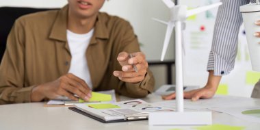 Genç bir profesyonel, modern bir ofis ortamında sürdürülebilirlik ve işbirliğine odaklanan çevre dostu bir projeye girişiyor..