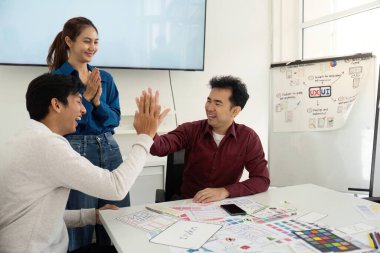 UX ve UI kavramları üzerinde işbirliği yapan tasarımcılar, dinamik bir buluşma ortamında eskizler ve fikirler paylaşıyorlar.