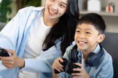 Bir anne ve oğlu video oyunları oynarken heyecan ve neşe ifade eder, aile bağlarını gözler önüne sererler..