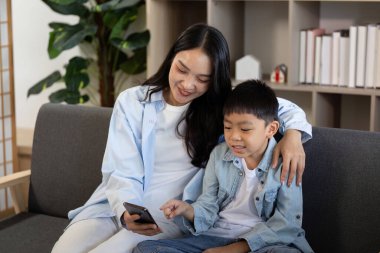 Bir anne ve oğlu arasında keyifli bir an. Akıllı bir telefondan ekranda zaman geçiriyorlar. Bağlantı ve nişanı geliştiriyorlar..