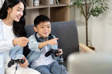 Bir anne ve oğlu video oyunları oynarken, aile bağlarını ve eğlencesini gösteren neşeli bir an..