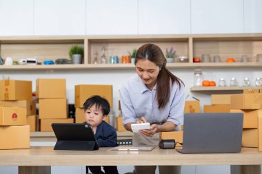 Bir anne çocuğuna evde bir tabletle yardım eder, ebeveynlik ve dijital nişanın karışımını gösterir..
