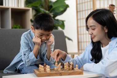 Genç bir çocuk satranç zaferini sevinçle kutluyor. Kazanmanın ve aile etkileşiminin heyecanını gözler önüne seriyor..