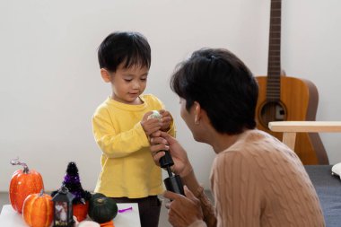 Bir baba ve oğul, yaratıcılık ve neşe yoluyla bağlarını güçlendirerek, Cadılar Bayramı süslemeleriyle eğlenceli anlar paylaşırlar..