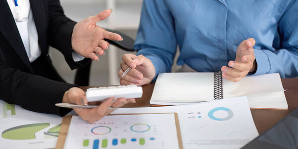 A financial advisor presents various investment options to a client, highlighting key data and strategies in a modern office setting.