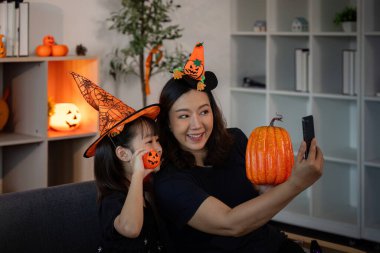 Neşeli bir anne-kız Cadılar Bayramı anılarını neşeli selfie 'ler ve balkabağı süslemeleriyle yakalıyorlar..