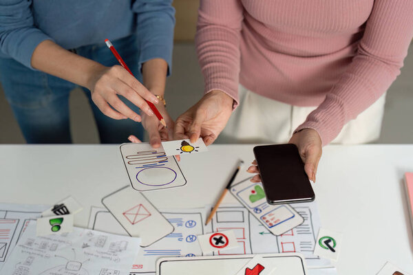 Two designers ideating and sketching user interface concepts, focusing on creativity and collaboration.