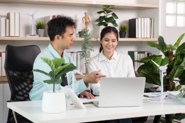 İki meslektaş, yeşil ofis ortamında sürdürülebilir mimari ve yenilenebilir enerji çözümleri hakkında bir tartışmaya girişti.