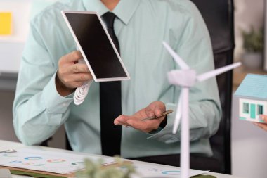 Takım üyeleri sürdürülebilir mimari, model ev ve rüzgar türbini üzerine bir tartışmaya girişiyor..