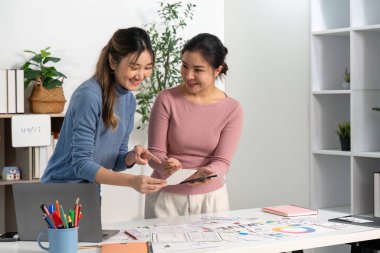 UX ve UI kavramları üzerinde işbirliği yapan tasarımcılar, canlı bir çalışma alanında fikir ve çizim alışverişinde bulunuyorlar..