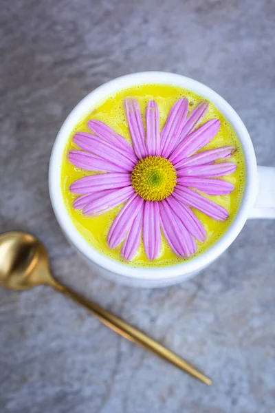 Latte Oro Una Tazza Bianca Decorata Con Una Margherita Rosa — Foto Stock