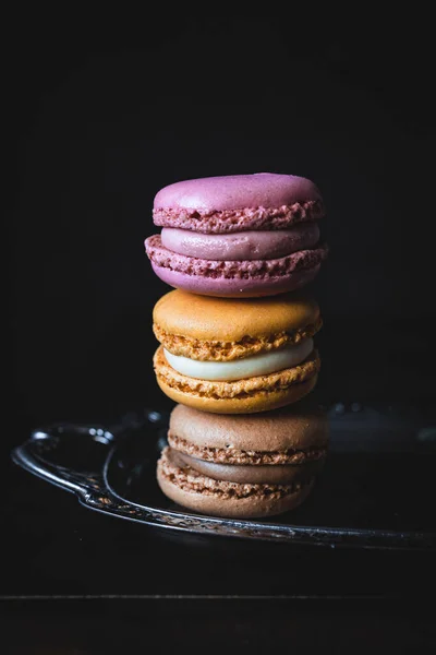 stock image Stack of colored macarons on silver tray and dark background