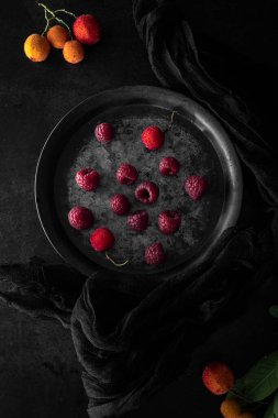 Metalik tabak ve taze ahududu. Fotokopi alanı olan karanlık ruh hali yiyecek fotoğrafçılığı