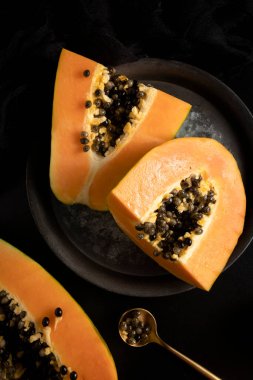 Olgun ve taze kesilmiş papaya. Koyu arkaplanı taze ve tropik meyveler.