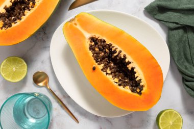 Tohumları ve beyaz zeminiyle olgun ve taze kesilmiş papaya. Taze ve tropikal meyve