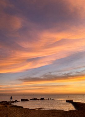 Akdeniz 'de güneşin doğuşunun fotoğraflarını çekiyorlar. Valencia sahilinde güneşin doğuşunu fotoğraflayan bir fotoğrafçı. Görkemli ve renkli gökyüzü.