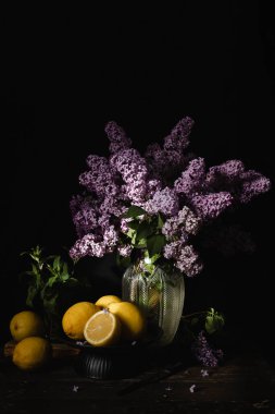 Bir demet leylak limonlarla dolu bir masada oturuyor..