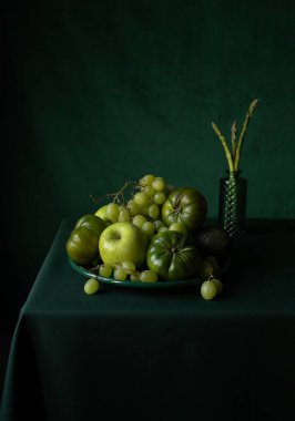 Yeşil arka planı olan bir masada yeşil meyve ve sebzeler