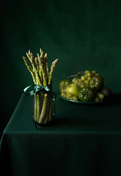 Green fruits and vegetables on a table with a green background