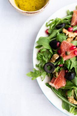 Roket (roket) ve greyfurtlu kuzu marul salatası, nar tohumu, siyah zeytin, kapari, ceviz ve hardal sirkesi soslu.