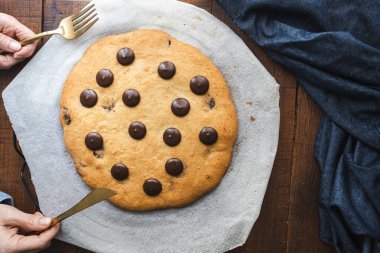 Dev çikolatalı kurabiye. Büyük ve lezzetli ev yapımı kurabiyeler ve siyah çikolata parçaları. Tatlıya düşkün olanlar için mükemmel bir kahvaltı ya da atıştırmalık.
