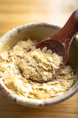 Bir kase yakın çekim ve besin maya ile ahşap kaşık, mükemmel vegan protein