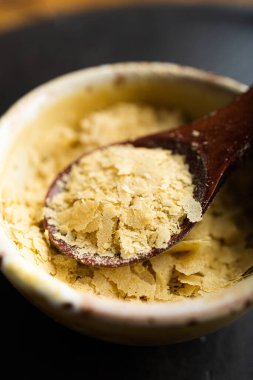 Bir kase yakın çekim ve besin maya ile ahşap kaşık, mükemmel vegan protein