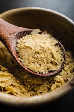 Bir kase yakın çekim ve besin maya ile ahşap kaşık, mükemmel vegan protein