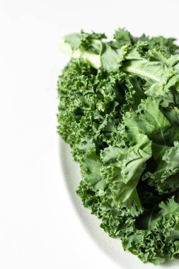 Beyaz arka planda bir demet taze lahana yaprağı.