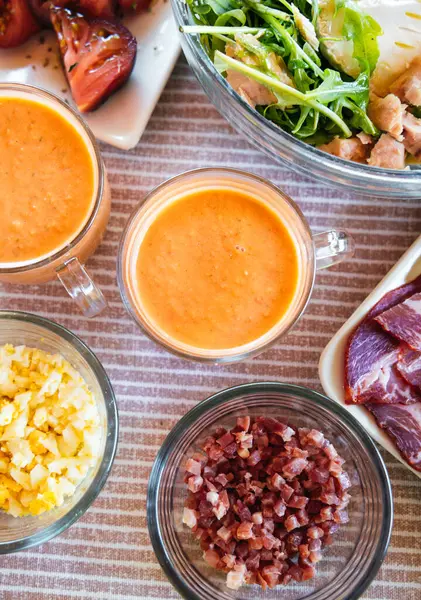 Salata, jambon, peynir, haşlanmış yumurta ve pita cipsi gibi çeşitli mezelerle servis edilen lezzetli salmorejo..