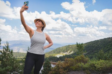 Bir kadın, İspanya 'nın Soria kentindeki Neila Lagünleri' nde akıllı telefonuyla selfie çekiyor..