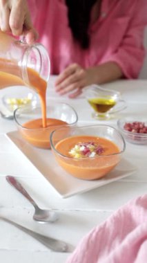 Haşlanmış yumurta ve jambonlu Salmorejo servis eden kız.