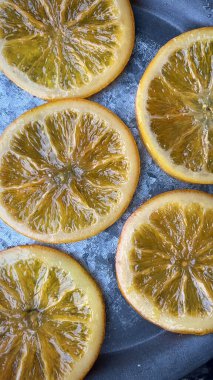 Düz bir yüzeyde soğuyan parlak karamelli portakal dilimleri, bitirilmiş tatlı ikramının zengin dokusunu ve parıltısını yakalıyor, tatlılar ve süslemeler için mükemmel..