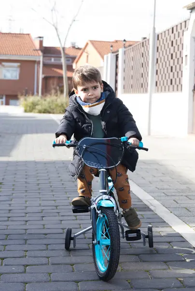 Eğitim tekerleriyle bisiklet süren bir çocuk. Bir kararlılık ve açık havada öğrenme anı