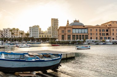 Puglia, Bari 'deki Porto Vecchio üzerinde nefes kesici bir günbatımı, tarihi balıkçı teknelerine sıcak altın renkler dökmek ve Adriyatik sularını sakinleştirmek