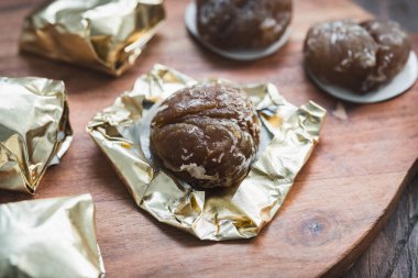 Ahşap bir yüzeyde geleneksel kestane ağacından bir cam kaplama, bu güzel mevsimlik şekerin parlak dokusunu ve zengin rengini gösteriyor.