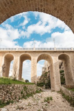 İtalya 'nın güneyindeki Polignano a Mare' de Lama Monachile sahilinden geçen tarihi bir taş köprü..