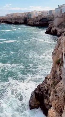 Puglia 'da Beyaz Binalar, Kayalıklar ve Açık Mavi Deniz' le Polignano a Mare 'nin Sahne Manzarası
