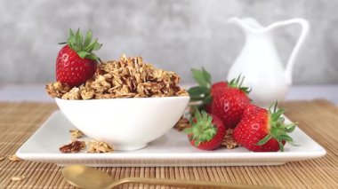 Sağlıklı ev yapımı granola taze çilek ile besleyici bir kahvaltıda servis edilir.